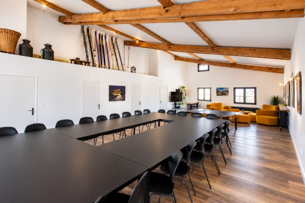 Grande salle de réunion aménagée en U dans un chalet à la montagne pour séminaire d'entreprise